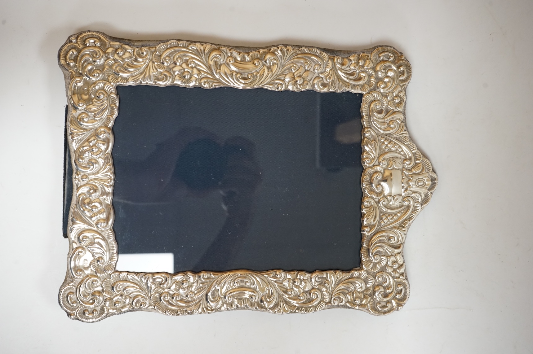A George V silver mounted rectangular photograph frame, with ribbon bow crest, by Stokes & Ireland Ltd, Chester, 1912, 18.2cm including crest, together with ten other modern silver mounted photograph frames, largest 29.4